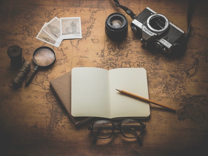 Travel planning desk with notebook and camera